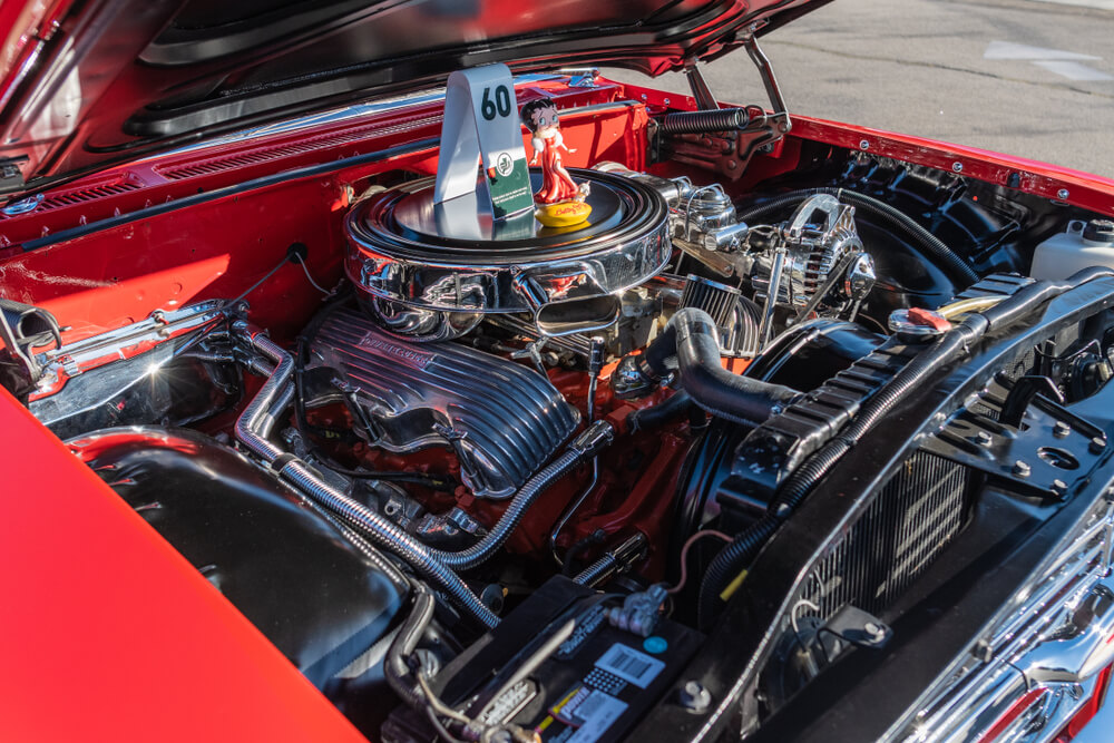 exposed engine of a red Chevrolet. - luxury cars bad mileage