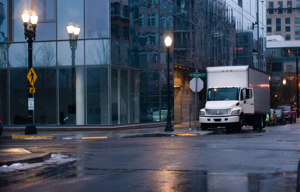 white box truck in a wet city street. 